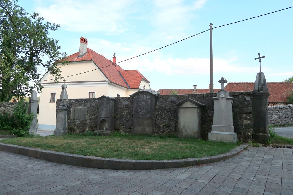 Vzdolž obzidja župnijske cerkve v Planini sekundarno postavljeni (starejši so vzidani) nagrobni spomeniki in plošča (foto: Simona Kermavnar)